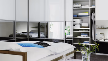 Ein begehbarer Kleiderschrank mit einem Stuhl und verschiedenen Kleidungsstücken.